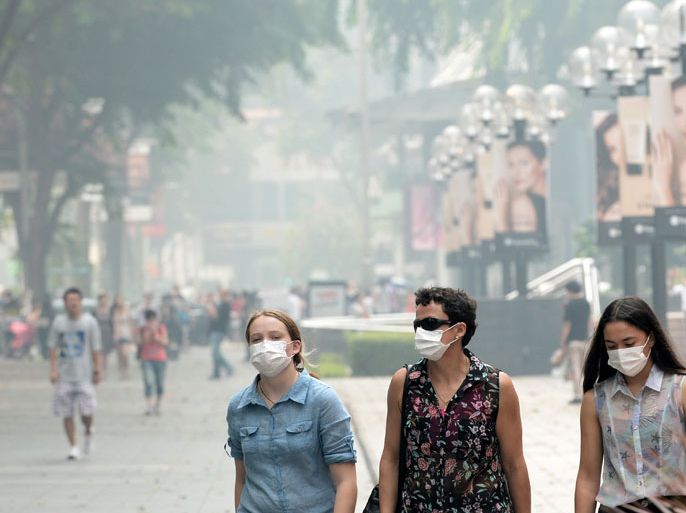 ROS654 - Singapore, -, SINGAPORE : People weat face masks on Orchard road in Singapore on June 22, 2013. Singapore will raise the regional smog problem at an upcoming ASEAN meeting and go after any local firms involved in starting forest fires in Indonesia, Foreign Minister K. Shanmugam said June 22. AFP PHOTO/Roslan Rahman