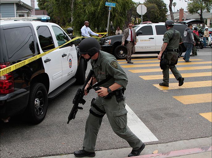 A SWAT officer walks on the street near the campus of Santa Monica College following a shooting at the school in Santa Monica, California, June 7, 2013. A gunman dressed in black killed four people in a string of shootings through the seaside California town of Santa Monica on Friday before he was shot dead by police in a community college library, law enforcement officials said. REUTERS/Jonathan Alcorn (UNITED STATES - Tags: CRIME LAW CIVIL UNREST EDUCATION)