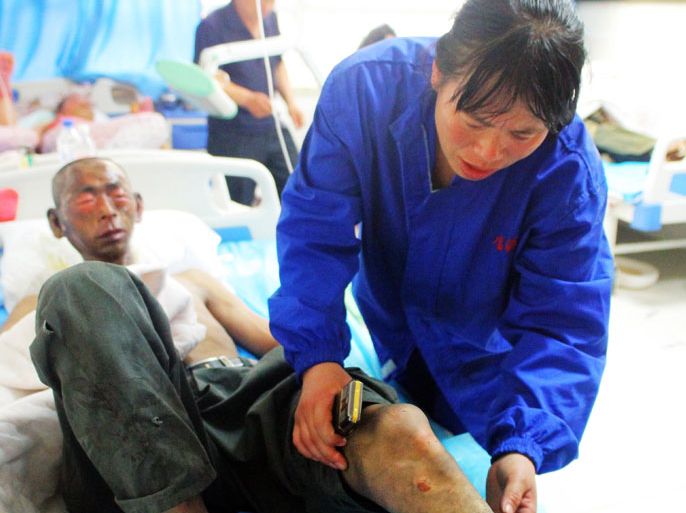 WH854 - Dehui, Jilin, CHINA : A victim (L) lies on a hospital bed after being rescued from a fire at Baoyuan poultry plant at Dehui, northeast China's Jilin province on June 3, 2013. At least 119 people were killed in a fire at a poultry processing plant in northeastern China on June 3, local officials said, in what appeared to be the country's worst blaze for 12 years. CHINA OUT AFP PHOTO