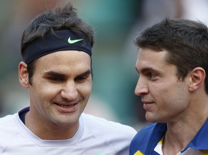 Switzerland's Roger Federer (L) embraces France's Gilles Simon at the end of their French Tennis Open round of sixteen match at the Roland Garros stadium in Paris, on June 2, 2013. AFP PHOTO / MARTIN BUREAU