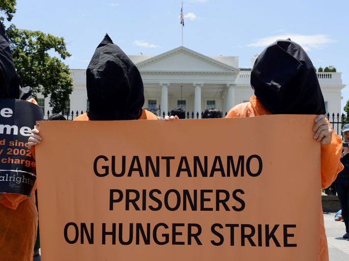 epa03745140 People dressed as detainees of Guantanamo Bay detention facility protest on Pennsylvania Avenue outside the White House in Washington DC, USA, 14 June 2013. Human rights groups have criticized the Obama administration for failing to close Guantanamo, which Obama originally promised to do in his first year in office. EPA/MICHAEL REYNOLDS