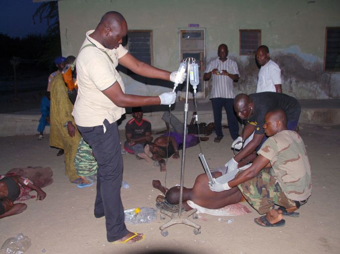 3 - Dawashe, -, NIGERIA : A handout picture released by the Nigerian army on July 28, 2013 shows Multinational Joint Task Force (MNJTF) medical officers treating on July 27, 2013 civilians injured by suspected members of the Boko Haram Islamist sect in the village of Dawashe, in the Kukawa district of the state of Borno. Suspected members of Nigeria's Islamist group Boko Haram shot dead more than 20 civilians when a vigilante group attacked them in the northern Borno state, a military spokesman said. AFP PHOTO / Nigerian army