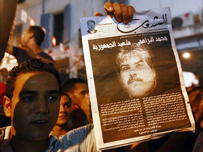 A demonstrator holds up a poster with an image of slain opposition figure Mohamed Brahimi to protest his assassination in Tunis, July 25, 2013. Brahmi was shot dead on Thursday in the second such assassination this year, setting off violent protests against the Islamist-led government in the capital and elsewhere. REUTERS/Anis Mili (TUNISIA - Tags: POLITICS CIVIL UNREST)