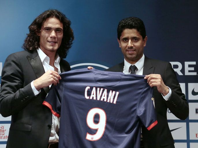 Paris Saint-Germain's (PSG) new forward, Edinson Cavani of Uruguay, and Paris Saint-Germain's (PSG)'s chairman Nasser Al-Khelaifi of Qatar (R) pose with Cavani's jersey during a press conference in Paris on July 16, 2013 after finalising Cavani's transfer to Paris Saint-Germain football club with sources close to the deal saying his 64-million-euro ($84 million) price tag would break the French record. AFP PHOTO / JACQUES DEMARTHON