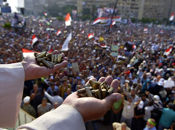 epa03781023 An Al-Azhar Muslim cleric carries spent bullets, allegedly used by security forces, are displayed as Egyptian supporters of ousted president Mohamed Morsi protest outside Rabaa al-Adawiya mosque in Cairo, Egypt, 08 July 2013. Clashes between Islamist protesters and the army in Cairo on 08 July killed at least 51 and injured 322 others. The army said fighting broke out after an armed group attempted to storm a Republican Guards facility, where Morsi's supporters believe he is held. A military source said that gunmen tried to penetrate the barbed wire surrounding the compound while snipers working in tandem fired from nearby rooftops. Muslim Brotherhood group said the army and police opened fire on supporters of the toppled president. EPA/YAHYA ARHAB EPA/YAHYA ARHAB
