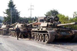 A handout picture released by the Syrian Arab News Agency (SANA) on August 8, 2013 shows Syrian army tanks parked on the side of a road during an alleged pursuit of opposition fighters in the Latakia province, western Syria. Syria took the rare step of denying reports of an attack on President Bashar al-Assad's motorcade as he drove to a Damascus mosque for prayers marking Muslim holidays. AFP PHOTO/HO/SANA