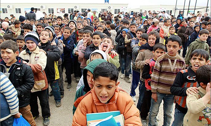 Syrian children, who are refugees, stand in queues at a school in Al- Zaatri refugee camp, in the Jordanian city of Mafraq, near the border with Syria February 12, 2013. The children resumed classes at school following a rainstorm three weeks ago that led the refugees at the camp to use the school building as a shelter. REUTERS/Muhammad Hamed (JORDAN - Tags: POLITICS EDUCATION)