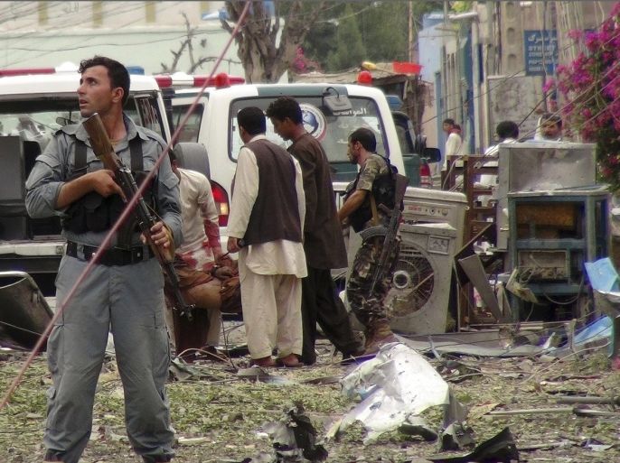 Security officials conduct investigation at the scene of suicide bomb attacks in Jalalabad, Afghanistan, Saturday, 3, 2013. Three suicide attackers killed at least nine civilians, most of them children, in a botched attack Saturday on the Indian consulate in an eastern Afghan city near the border with Pakistan, security officials said.