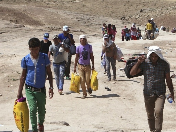لاجئون سوريون يعبرون الحدود إلى كردستان العراق (رويترز)