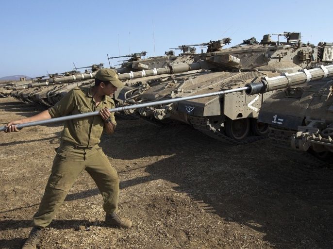 An Israeli soldier checks a Merkava tank stationed in the Israeli-occupied Golan Heights along the border with Syria on September 1, 2013. The Israeli cabinet authorised on August 28 a partial call-up of army reservists amid growing expectations of a foreign military strike on neighbouring Syria, army radio reported. The unspecified number of troops are attached to units stationed in the north of the country, which borders both Lebanon and the Golan Heights.