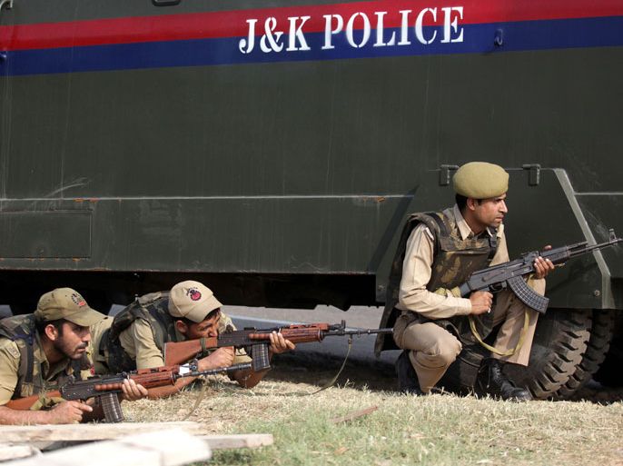 Indian police officials take position behind a vehicle during an attack by militants on an army camp at Mesar in Samba District, some 20kms south-east of Jammu on September 26, 2013. Militants disguised as soldiers killed seven people in an attack on a police base in Indian Kashmir, days before long-awaited talks between the leaders of India and Pakistan, police said. The attackers then escaped after hijacking a truck and were now engaged in a fierce gun battle with Indian troops in Samba district of the region near the border with Pakistan, the NDTV news network and other local media reported. AFP