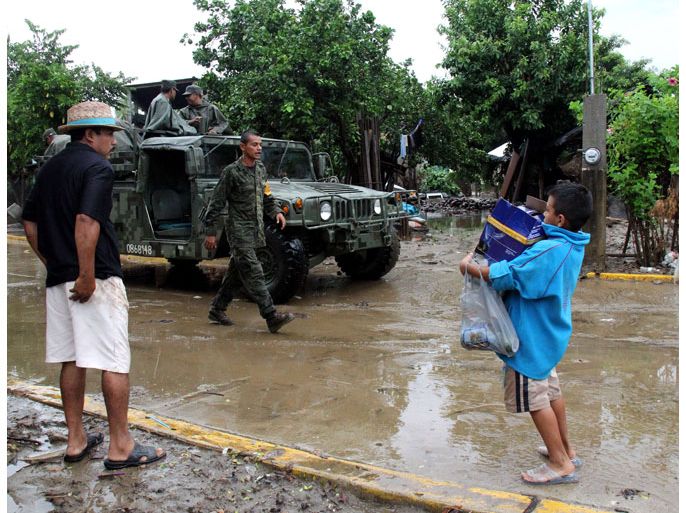 Coyuca de Benitez, Guerrero, MEXICO : Mexican soldiers help to evacuate residents as Hurricane Raymond approaches, in Coyuca de Benitez on October 21, 2013 in the state of Guerrero. Hurricane Raymond -- Category Three force on the five-level Saffir-Simpson scale-- swirled off Mexico's Pacific coast, forcing schools to close and more than 1,000 people to leave homes in a region reeling from recent deadly floods and landslides. AFP PHOTO