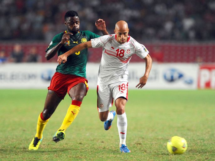 Tunisian defender Yassine Mikeri (18) vies for the ball with Cameroon's forward Bilong Song (L) during the FIFA World Cup qualification match between Tunisia and Cameroon on October 13, 2013 in Rades Olympic Stadium in Tunis. AFP PHOTO/ FETHI BELAID
