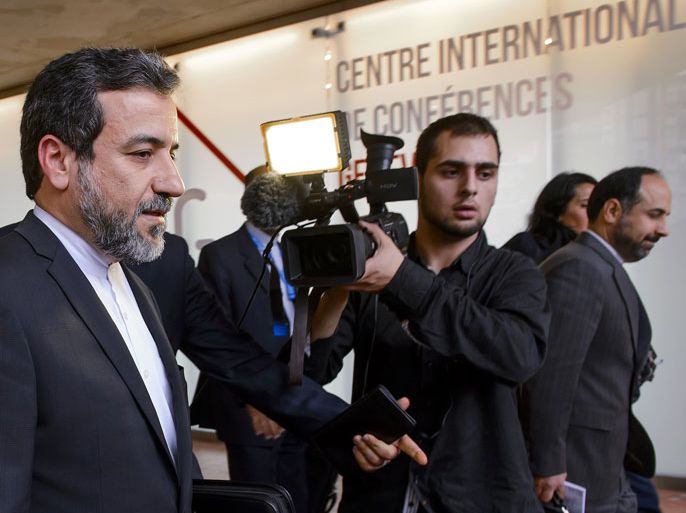 Iran's Deputy Foreign minister Abbas Araghchi (L) leaves the media center after the start of two days of closed-door nuclear talks on October 15, 2013 at the United Nations offices in Geneva. World powers and Iran began fresh talks on Tehran's controversial nuclear programme, after a six-month hiatus over its refusal to curb uranium enrichment in exchange for easing sanctions. AFP PHOTO / FABRICE COFFRINI