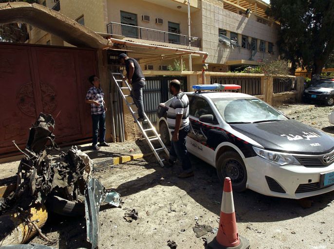 DO003 - BENGHAZI, -, LIBYA : Libyan police and bystanders gather at the scene of car bomb explosion outside the Swedish consulate in the eastern Libyan city of Benghazi on October 11, 2013 which seriously damaged the building but caused no casualties. The Swedish mission is one of the few remaining diplomatic offices remaining in Benghazi, which was the cradle of uprising and frequently sees attacks on security personnel and institutions. AFP PHOTO/ABDULLAH DOMA