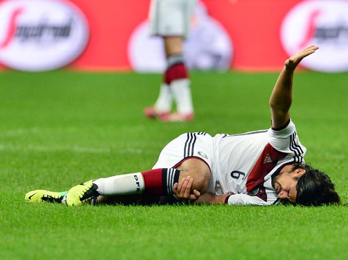 Germany's midfielder Sami Khedira reacts in pain during a friendly football match between Italy and Germany on November 15, 2013 at the San Siro Stadium in Milan. AFP PHOTO / GIUSEPPE CACACE