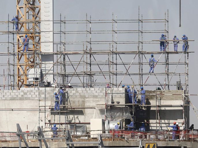 Labourers install scaffolding at the construction site of an International Islamic Bank tower under construction in Doha December 24, 2012. REUTERS/Fadi Al-Assaad (QATAR - Tags: BUSINESS CONSTRUCTION)