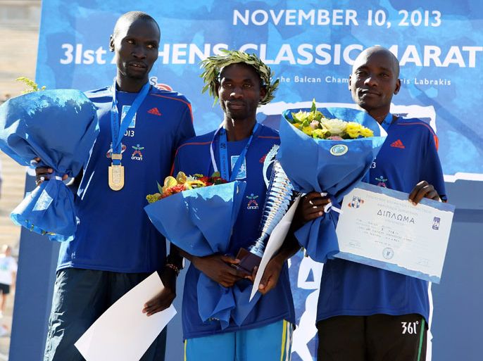 Kenya's Hillary Kipkogei Yego (C) poses on the podium after winning the 31st Athens classic marathon, in a time of 2:13.59, ahead of Dickson Kimeli (L) who clocked 2:14.40 and Kipkorir Rutoh (R) who took third at 2:14.47, in Athens on November 10, 2013. Some 17,000 runners from 102 countries took part in the classic marathon which began just a short distance from the tumulus erected for the Greek dead of the battle of Marathon and finishing at the all-marble Panathenaic Stadium, site of the first modern Olympics in 1896. AFP PHOTO / STR