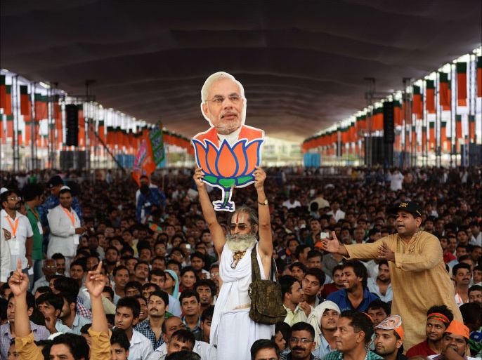 FILES) In this photograph taken on September 29, 2013, a supporter of the Bharatiya Janata Party(BJP) holds a cutout of Gujarat state Chief Minister and the Bharatiya Janata Party's (BJP) prime ministerial candidate Narendra Modi during an