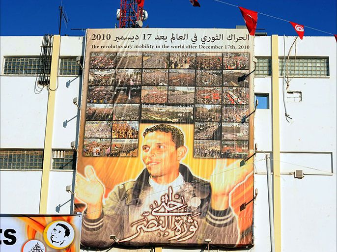 A giant portrait of Tunisian protestor Mohamed Bouazizi hangs on the wall  in the central town of Sidi Bouzid on December 17, 2013, as they celebrate the 3rd anniversary of the start of the revolution, the first of the Arab Spring uprisings, triggered by the self-immolation of Bouazizi, the vegetable vendor harassed by poverty and police atrocity. Tunisians gathered today at the birthplace of the Arab Spring to vent their anger at social exclusion three years