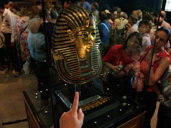 Tourists gather around the mask of the most famous Pharaonic royal, King Tutankhamun, at the Egyptian Museum in Cairo on April 13, 2008. The young king died in his late teens and remained at rest in Egypt's Valley of the Kings for over 3,300 years, until in November 1922, Tutankhamun's tomb was discovered by the British Egyptologist Howard Carter.