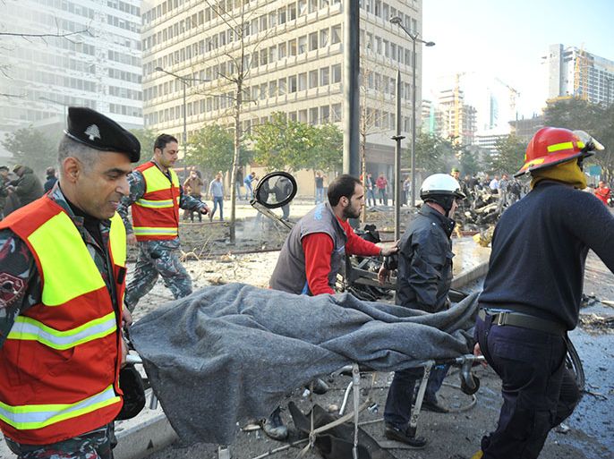 Lebanese security forces and rescue teams carry a cropse on a stretcher at the scene of a huge car bomb explosion that rocked central Beirut on December 27, 2013, killing Mohamed Chatah (Shatah), former finance minister and adviser to Lebanese ex-premier Saad Hariri, along with at least four others, according to initial reports from the Lebanese capital. AFP