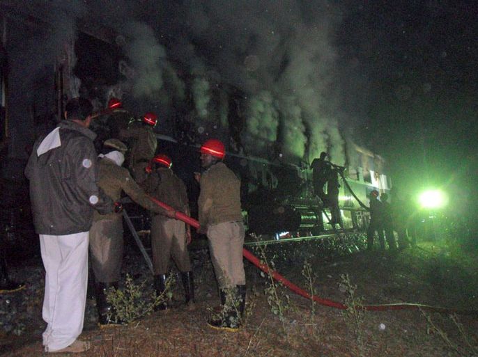 Indian rescue personnel attempt to extinguish fire in a burning carriage of the Nanded-Bangalore Express near Puttapartihi in Ananthpur District some 300kms south of Hyderabad early December 28, 2013, after a fire engulfed the train. A fire on an overnight train killed at least 23 people in southern India as it ripped through a carriage packed with sleeping passengers, officials said. AFP