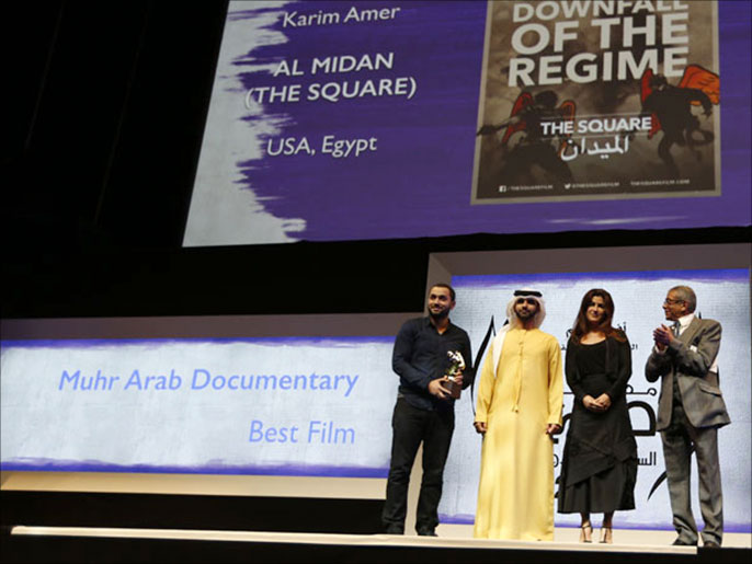 ‪المخرج المصري كريم عامر(يسار) يتسلم جائزة افضل فيلم وثائقي بالمهرجان عن فيلم 