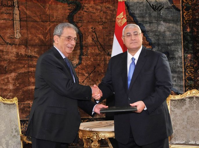 Egypt's interim President Adly Mansour (R) receives a finalized draft constitution from Egypt's constituent assembly Chairman Amr Moussa, during their meeting at El-Thadiya presidential palace in Cairo in this December 3, 2013 handout picture. The constitution will be put to a referendum this month or next and is a major milestone in the army's political roadmap after the ouster of Islamist President Mohamed Mursi in July. REUTERS/Egyptian Presidency/Handout via Reuters (EGYPT - Tags: POLITICS MILITARY) ATTENTION EDITORS - NO SALES. NO ARCHIVES. THIS IMAGE WAS PROVIDED BY A THIRD PARTY. FOR EDITORIAL USE ONLY. NOT FOR SALE FOR MARKETING OR ADVERTISING CAMPAIGNS. THIS PICTURE IS DISTRIBUTED EXACTLY AS RECEIVED BY REUTERS, AS A SERVICE TO CLIENTS