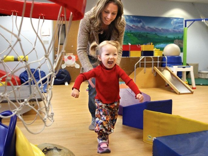 Cora Dove Burton, 2 1/2 years old, of Kennewick happily runs to the beginning of a therapy course with Tawnya Martineau, occupational therapy assistant at the Children's Developmental Center, Tuesday Dec. 17, 2013, in Richland, Wash. The center works with about 700 children, from newborns up to three-year-olds, who have developmental delays and challenges. Puppets with mouths that open, textured and board books and toys for babies and toddlers are on the center’s wish list this holiday season as well as office supplies. (AP Photo/The Tri-City Herald, Paul T. Erickson) LOCAL TV OUT; LOCAL RADIO OUT KONA