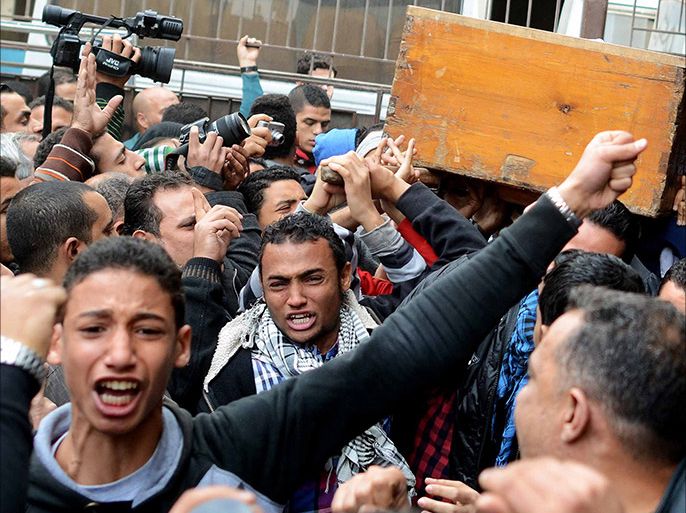 People mourn as they carry the coffin of one of the victims of clashes between supporters and opponents of Egypt's military, on January 26, 2014 outside the Zinhom Morgue, outside Cairo, Egypt. Nearly 50 people died in weekend