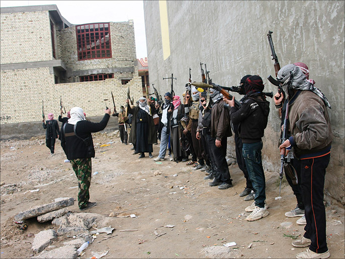 عدد من مسلحي القبائل يتجمعون قبل الانتشار في شوارع الفلوجة (رويترز)