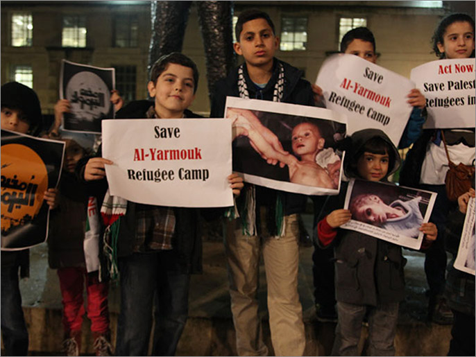 الأطفال حملوا صور بعض ضحايا المخيم المحاصر (الجزيرة نت)