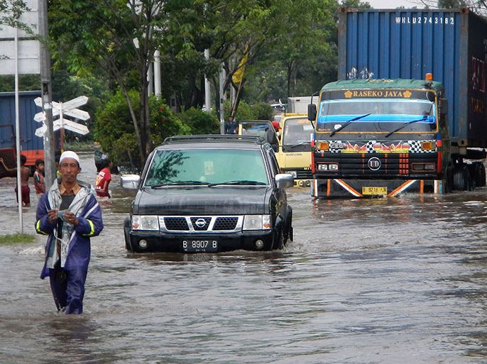 Vehicles drive on a flooded road in Jakarta on January 17, 2014. Indonesia is regularly affected by deadly floods and landslides during its wet season, which lasts for around six months. Environmentalists blame logging and a failure to reforest denuded land for exacerbating the floods. AFP