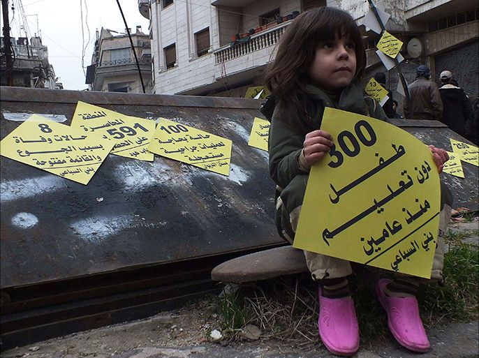 A girl carries a sign that reads '300 children without education since two years' during a campaign organised by activists in the besieged area of Homs, January 22, 2014. Activists erected yellow signs in the besieged area of Homs as part of a campaign called "Yellow covers the besieged area of Homs". The campaign aims to shed light on what is happening inside the area which is suffering severe food and medical shortages, and calling on humanitarian organisations to help and evacuate the families and wounded people. REUTERS/Yazan Homsy (SYRIA - Tags: POLITICS CIVIL UNREST CONFLICT TPX IMAGES OF THE DAY)
