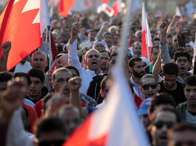 Thousands of Bahraini anti-government protesters chant slogans as they wave national flags during a march in Diraz, Bahrain, on Friday, Jan. 17, 2014. Demonstrators called for the prime minister to step down, political prisoners to be freed and democracy in the Gulf island nation. (AP Photo/Hasan Jamali)