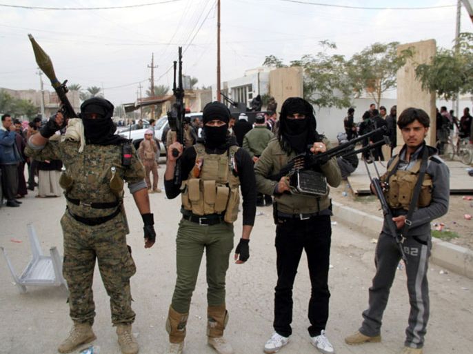 Masked Sunni fighters stand at a street in Ramadi city, western Iraq on 29 December 2013. Reports state that Iraqi forces has launched a military operation in the city a day after five people were killed on 28 December 2103