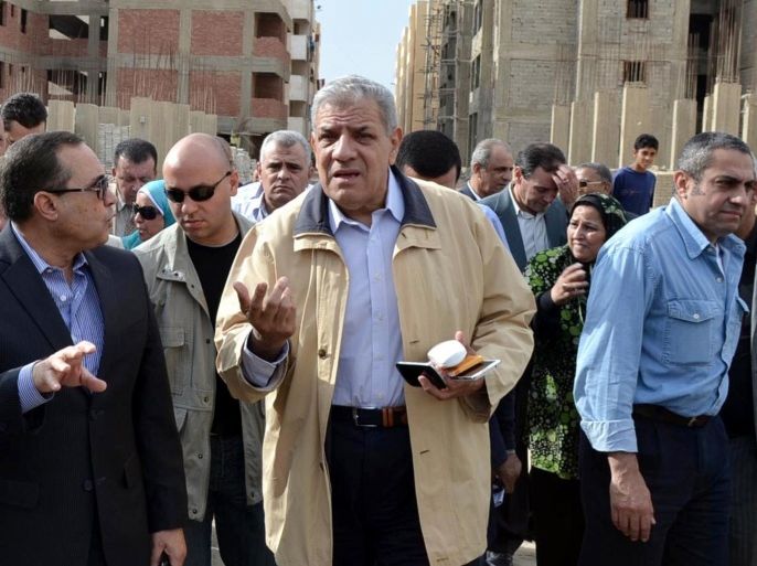 In this Nov. 24, 2013 photo, Ibrahim Mehlib, center, tours a government housing project in Ismailiya, Egypt. Egypt's interim president has chosen as prime minister a construction magnate from the era of ousted autocrat Hosni Mubarak. Adly Mansour on Tuesday, Feb. 25, 2014 named Mehlib, who had for more than a decade led Egypt's biggest construction company, Arab Contractors, to replace Hazem el-Beblawi, who resigned on Monday.(AP Photo/Khaled Kandil)