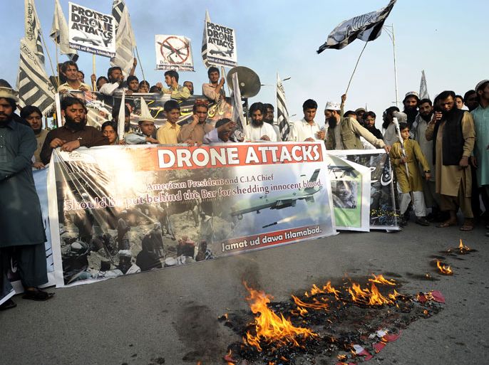 epa03932155 Supporters of the banned Islamic charity organization Jamat-ud-Dawa burn a mock US flag as they shout slogans during a protest against an US drone attack in North-Waziristran tribal agency, in Islamabad, Pakistan, 01 November 2013. The Pakistani government expressed its anger on 31 October, after an alleged US drone attack killed three suspected militants in the country's north-western region. According to media reports, a drone fired two missiles on a compound in Miramshah, the headquarters of North Waziristan tribal district near the Afghan border. The attack, the first in a month, came days after Prime Minister Nawaz Sharif asked US President Barack Obama to end drone operations during a visit to Washington. EPA/T. MUGHAL