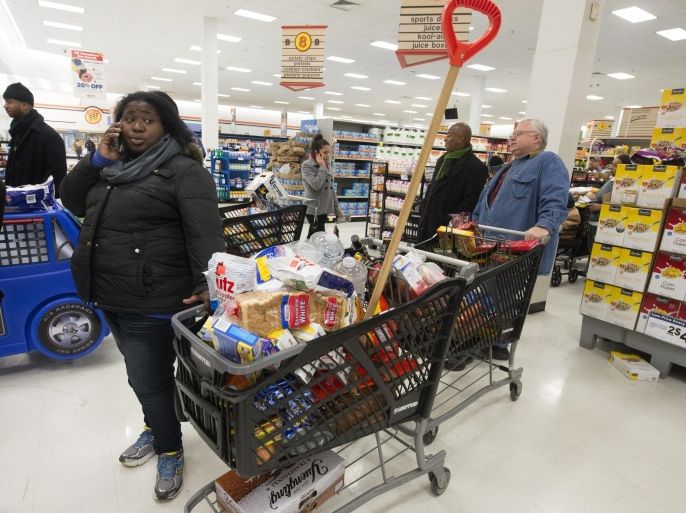 A shopper at a grocery store waits in a long line with items such as a food and a snow shovel, seen at center, as people stocked up on items ahead of an approaching snowstorm, in Alexandria, Virginia, USA, 12 February 2014. Weather forecasts predict between five to ten inches of snow (around 12 to 25 cm) overnight in the Washington DC area, as a major snowstorm moves up the mid-Atlantic to the Northeast region of the US.