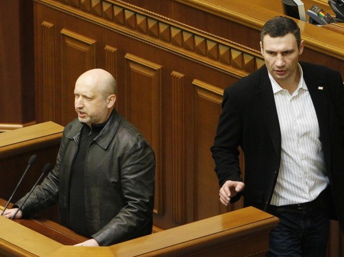 Ukrainian opposition leader Vitaly Klitschko (R) passes by newly elected speaker of parliament Oleksander Turchynov during a session of the Ukrainian parliament in Kiev February 22, 2014. Protesters seized the Kiev office of President Viktor Yanukovich on Saturday and the opposition demanded a new election be held by May, as the pro-Russian leader's grip on power rapidly eroded following bloodshed in the capital. The speaker of parliament, a Yanukovich loyalist, resigned and parliament on Saturday elected Oleksander Turchynov, a close ally of Tymoshenko, as his replacement. REUTERS/Andrii Skakodub (UKRAINE - Tags: POLITICS CIVIL UNREST TPX IMAGES OF THE DAY)