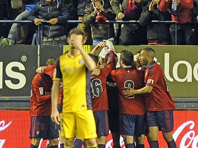 Osasuna's players celebrate their second goal during the Spanish league football match Osasuna vs Atletico de Madrid at El Sadar stadium in Pamplona on February 23, 2014. AFP