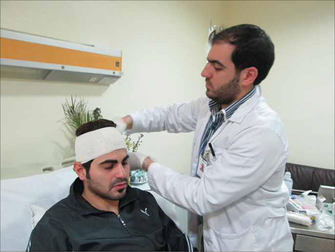 الطبيب إيهاب أبو سعدة يتلقى العلاج بعد الاعتداء عليه (الجزيرة)