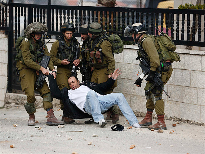جنود إسرائيليون ينقضون على مواطن فلسطيني ويعتقلونه (رويترز-أرشيف)