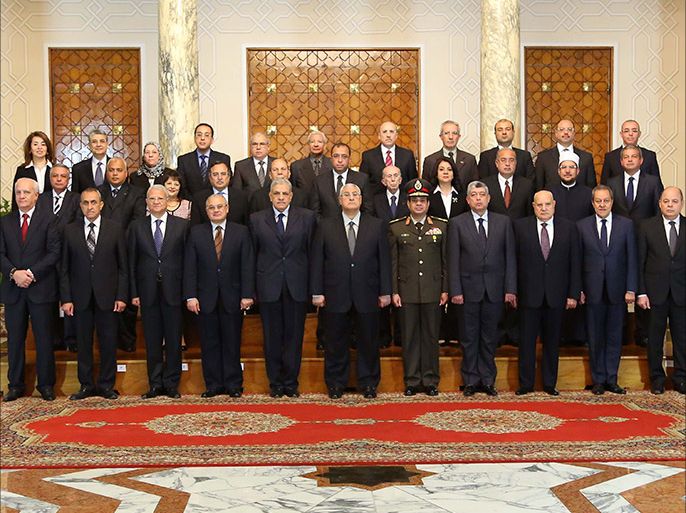 A handout picture made available by the Egyptian presidency shows Egypt's interim president Adly Mansour (C) posing with the newly-appointed cabinet members during the swearing in ceremony at the presidential palace in Cairo on March 1, 2014.