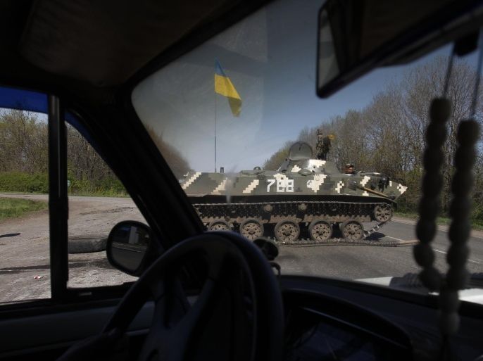 Seen through a car window, Ukrainian soldiers block a road near the village of of Malinovka, 20 kilometers (12,5 miles) from Slovyansk, eastern Ukraine, Sunday, April 27, 2014. Insurgents in Slovyansk have taken a number of people hostage, including journalists and pro-Ukraine activists, as they strengthen their control in the east of the country in defiance of the interim government in Kiev and its Western supporters. (AP Photo/Sergei Grits)