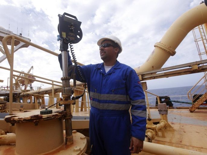 A worker inspects the metering system of an oil tank at Libya's Bouri offshore oilfield, 130 km (81 miles) north of Tripoli October 9, 2013. Libya is producing almost 40,000 barrels a day at its Bouri offshore oilfield, jointly run with Italy's ENI, and plans to add up to 15,000 bpd within six months by launching new drilling technology, executives said on Wednesday. REUTERS/Ismail Zitouny (LIBYA - Tags: ENERGY BUSINESS)