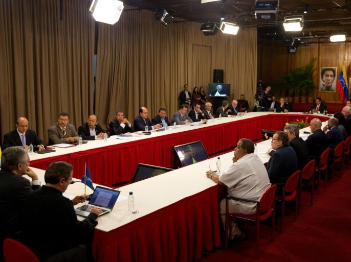 Opposition members, top, and government representatives, bottom right, meet at Miraflores presidential palace in Caracas, Venezuela, Thursday, April 10, 2014. President Nicolas Maduro and key members of the opposition met for a much-anticipated meeting aimed at reconciliation since protests began in early February. Maduro sits at the right end of the table. (AP Photo/Fernando Llano)
