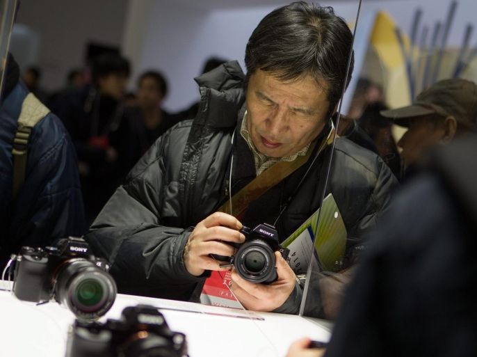 A visitor tries out a Sony A7 camera at the CP+ Camera and Photo Imaging Show in Yokohama, near Tokyo, Japan, 13 February 2014. CP+ is known as Japan's largest camera expo showcasing a wide range of photographic equipment and accessories where visitors can participate in a hands on experience. The show runs from 13-16 February.