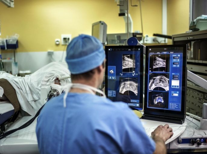 A surgeon sitting in front of screens of a Focal One device performs a robot-assisted prostate tumorectomy using ultrasound imaging on April 10, 2014 at the Edouard Herriot hospital in Lyon, center France. Focal One is the first robotic HIFU (high intensity focused ultrasound) device dedicated to the focal approach for prostate cancer therapy. According to EDAP TMS SA, a leader in therapeutic ultrasound, it combines the three essential components to efficiently perform a focal treatment: state-of-the-art imaging to localized tumors with the use of magnetic resonance imaging (MRI) combined with real-time ultrasound, utmost precision of robotic HIFU treatment focused only on identified targeted cancer areas, and immediate feedback on treatment efficacy utilizing Contrast-Enhanced Ultrasound Imaging. AFP PHOTO / JEFF PACHOUD